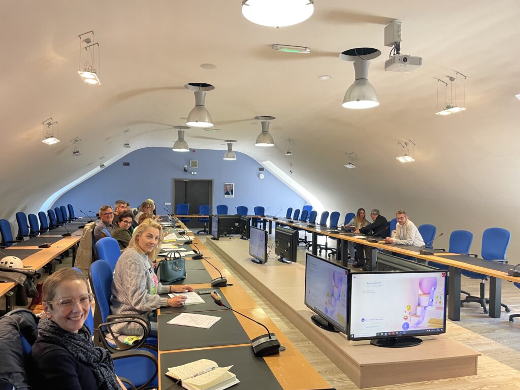 Photo d'un groupe de personnes autour de tables dans une salle de réunion